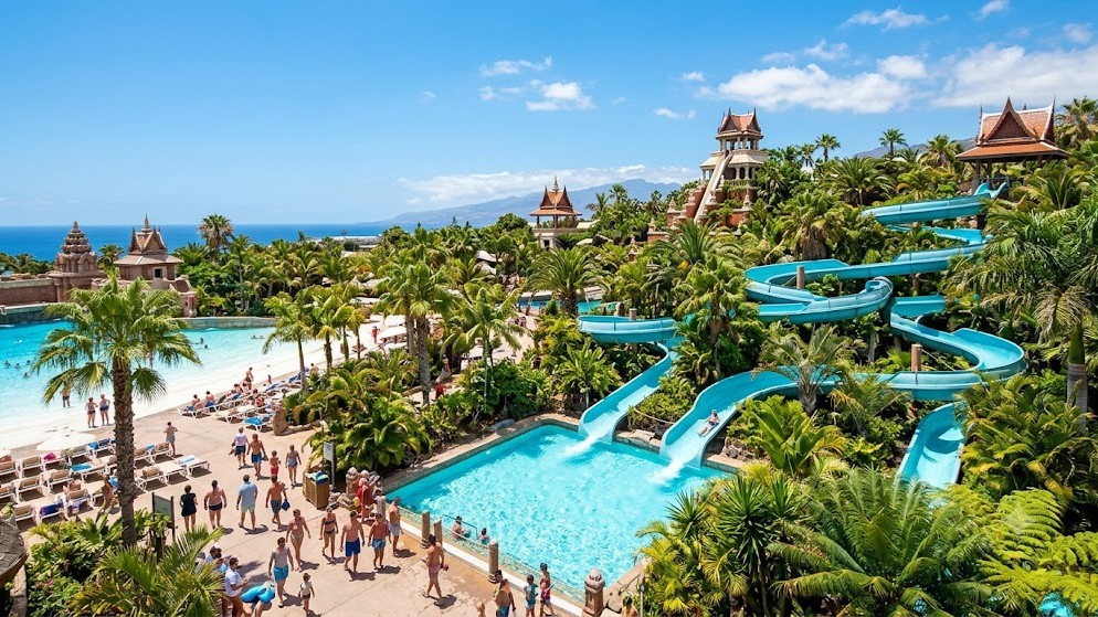 Siam Park Tenerife water slides, turquoise pools, and lush tropical palms under sunny skies during the shoulder months